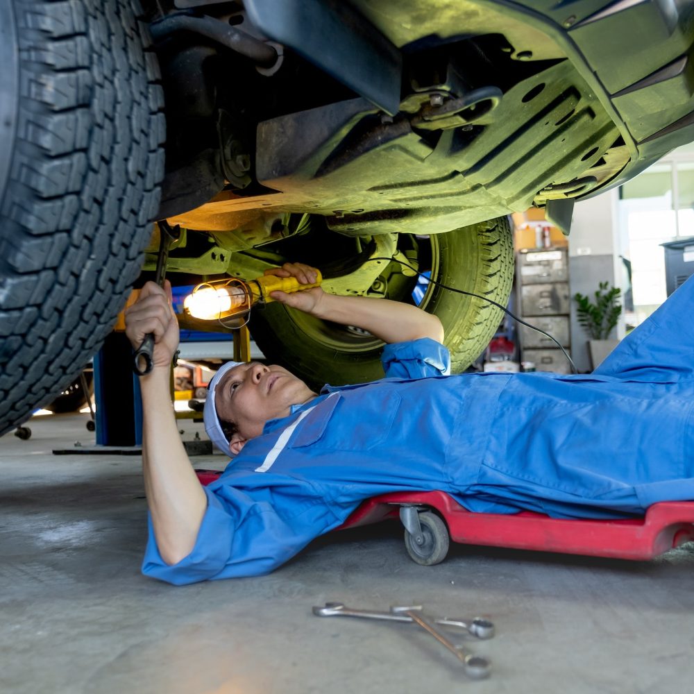 technician-or-garage-worker-lie-down-under-the-car-and-use-lantern-to-guide-for-fix-the-problem.jpg